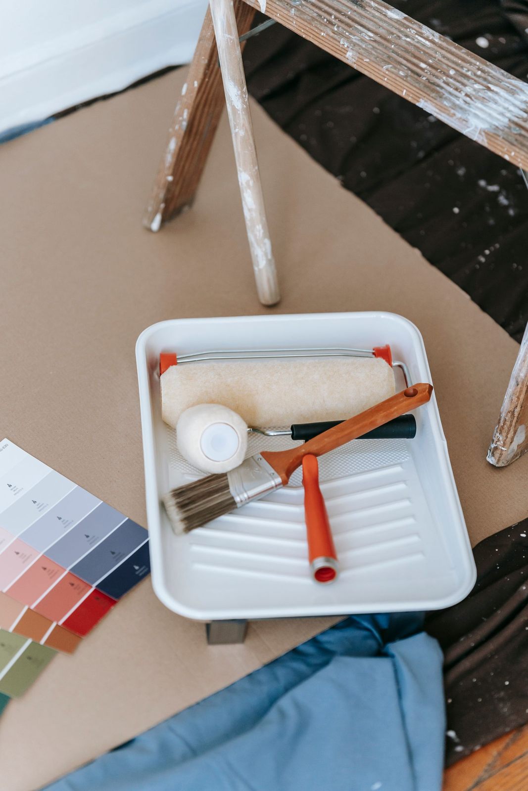 A well-organized setup for a DIY home painting project, complete with tools and color swatches
